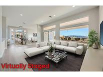 Bright, open-concept living room featuring a sleek white sectional and expansive view windows at 2904 Bow Bridge Dr, Las Vegas, NV 89134