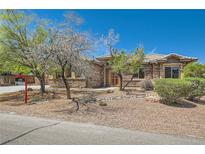Charming single-story home featuring a stone facade, well-maintained landscaping, and desert surroundings at 3910 Internet Ave, North Las Vegas, NV 89031