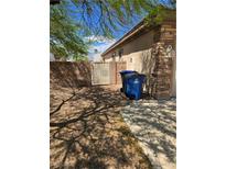 Side yard featuring rock landscaping, privacy wall, and gate access to the house at 3910 Internet Ave, North Las Vegas, NV 89031