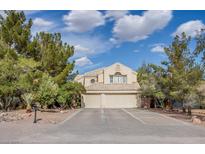 Charming two-story home featuring a three-car garage, desert landscaping, and a tile roof at 5180 N Dapple Gray Rd, Las Vegas, NV 89149
