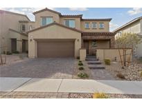 Two-story home with desert landscaping, paver driveway, and covered front porch at 595 Beverly Pine Pl, Henderson, NV 89011