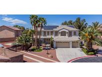 Expansive two-story home featuring a three-car garage, desert landscaping and solar panels on the roof at 7141 Groveton Ct, Las Vegas, NV 89131