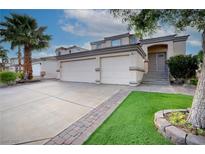 Charming stucco home featuring a three-car garage, desert landscaping, and covered front entry at 760 Camino La Paz, Henderson, NV 89012
