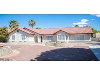 Charming single-story home with a red tile roof and well-maintained landscaping featuring mature palm trees at 8340 W Fisher Ave, Las Vegas, NV 89149
