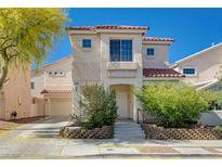 Charming two-story home with a red tile roof, landscaped front yard and attached two car garage at 9004 Snowtrack Ave, Las Vegas, NV 89149