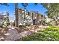 Charming townhouse featuring a brick walkway, mature trees, and well-maintained landscaping at 1030 Tam O Shanter, Las Vegas, NV 89109