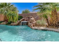 Backyard pool featuring a rock waterfall, beautiful tile work and surrounded by palm trees at 10519 Bella Camrosa Dr, Las Vegas, NV 89141