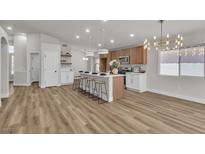 Bright kitchen features an island with seating, modern light fixtures, and stainless steel appliances at 10886 Porto Foxi St, Las Vegas, NV 89141