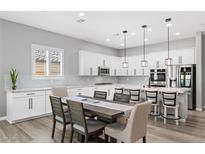 Bright, modern kitchen featuring white cabinets, stainless steel appliances, and a central island with bar seating at 10968 Tracy Stevens Ave, Las Vegas, NV 89166