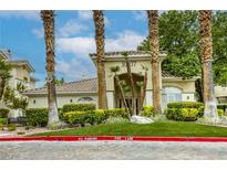 Charming building entrance framed by palm trees and lush landscaping at 1420 Red Crest Ln # 202, Las Vegas, NV 89144
