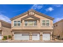 Beige two-story home with three-car garage and well-maintained landscaping at 1612 Lefty Garcia Way, Henderson, NV 89002