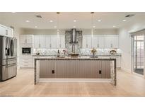 Spacious kitchen with white cabinetry, stainless steel appliances, and a large center island with granite countertop at 2372 Perrysburg Dr, Henderson, NV 89044