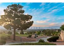 Expansive views of the golf course and city skyline, framed by mature trees and a clear blue sky at 2742 Darby Falls Dr, Las Vegas, NV 89134
