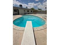 Backyard swimming pool with diving board and concrete deck surrounded by single story home at 2804 E Gowan Rd, North Las Vegas, NV 89030