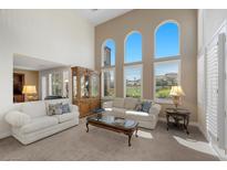 Bright living room featuring high ceilings, large arched windows, and comfortable seating arrangements at 2933 Red Springs Dr, Las Vegas, NV 89135