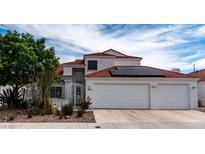 Two-story home with a white exterior, red tile roof, three-car garage, and a well-manicured front yard at 3008 Blue Fin Cir, Las Vegas, NV 89128