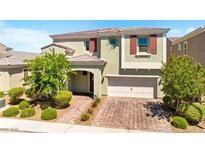 Charming two-story home featuring a brick driveway, an attached two-car garage, and a beautifully landscaped front yard at 3042 Echoed Rondel Ln, Henderson, NV 89044