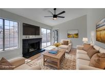 Bright living room with a cozy fireplace and sliding glass door to the backyard at 3800 Summer Breeze Cir, Las Vegas, NV 89108
