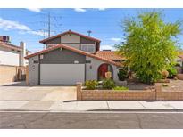 Two-story home with a two-car garage, brick landscaping, and a red tile roof at 5361 Cabrito Dr, Las Vegas, NV 89103
