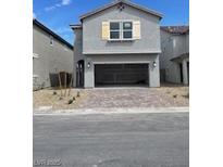 Two-story home featuring a brick driveway leading to an attached two-car garage and light shutters at 6574 Tumoulin St, Las Vegas, NV 89148