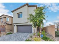 Two story home featuring a gray garage door, neutral stucco, and manicured landscaping at 816 Sand Camel Ct, North Las Vegas, NV 89081