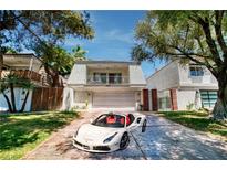 Charming two-story home with a well-manicured lawn and a luxury sports car in the driveway at 940 Vegas Valley Dr, Las Vegas, NV 89109