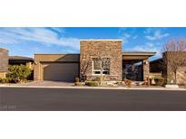 Contemporary home featuring a stone facade, well-manicured landscaping, and a two-car garage at 9858 Gemstone Sunset Ave, Las Vegas, NV 89148