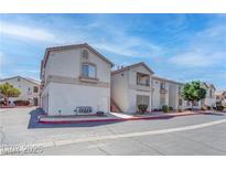 View of the building featuring a cream-colored stucco exterior, red roof tiles, and well-maintained landscaping at 1300 S Arlington St # 202, Las Vegas, NV 89104