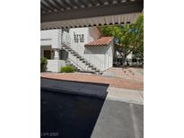 Condo exterior with white facade, staircase, and landscaped grounds at 2713 Otter Creek Ct # 202, Las Vegas, NV 89117