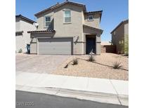 Charming two-story home featuring a neutral stucco facade, a two-car garage, and a low maintenance desert landscape at 438 Shimmering Sands Ave, North Las Vegas, NV 89031