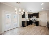 Bright eat-in kitchen features stainless appliances, dark cabinetry, and stylish chandelier lighting at 5439 Bradford Pear Dr, Las Vegas, NV 89122