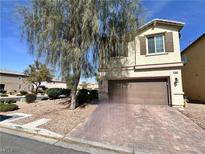 Two-story home featuring a paver driveway and a mature tree providing shade in the front yard at 5634 Bishop Flowers St, Las Vegas, NV 89130
