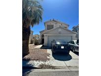 Two-story home showcasing the front exterior with an attached garage and desert landscaping at 5711 Roundrock Dr, Las Vegas, NV 89142