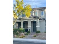 Charming two-story home features a welcoming front entrance with arched doorways and a landscaped yard at 946 Belton Lake Ave, North Las Vegas, NV 89086