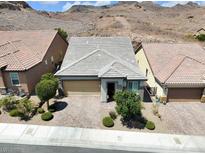 Charming single-story home featuring well-manicured landscaping, a two-car garage, and desert views at 1063 Upper Springs St, Henderson, NV 89002