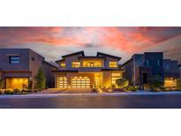 Stunning modern home featuring a three-car garage and beautiful sunset views at twilight at 10748 Steel Ridge Ct, Las Vegas, NV 89135
