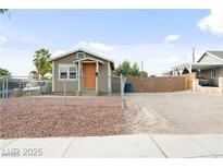 Charming single story home featuring a large gravel driveway and orange front door at 1718 Marlin Ave, Las Vegas, NV 89101