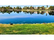 Beautiful lake view with lush greenery and clear reflections of the homes across the water at 2529 Seascape Dr, Las Vegas, NV 89128