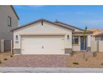 Charming single-story home with a two-car garage, brick driveway, and desert landscaping at 2611 Freya Valley St, Las Vegas, NV 89156