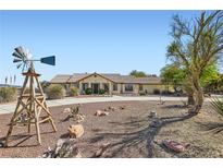 Charming single-story home with desert landscaping and a decorative windmill on a spacious lot at 4075 W Torino Ave, Las Vegas, NV 89139