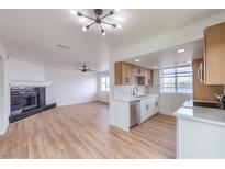Open-concept living room and kitchen area with fireplace and updated flooring at 5335 Rod Ct # 103, Las Vegas, NV 89122
