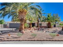 Charming single-story home featuring a well-manicured front yard with desert landscaping and mature palm trees at 6117 Foxcroft Ave, Las Vegas, NV 89108