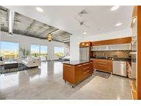 Modern living room open to kitchen, featuring sleek concrete floors and expansive city views from large windows at 900 Las Vegas Blvd # 1014, Las Vegas, NV 89101