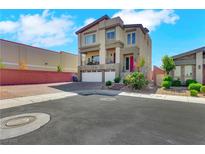 A modern two-story home featuring a stucco facade, balcony, two-car garage, and low-maintenance landscaping at 9045 Knots Estate St, Las Vegas, NV 89139
