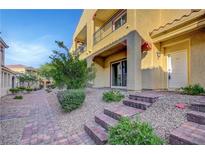 Inviting townhouse entrance with brick steps, desert landscaping, and charming curb appeal at 985 Via Lombardi Ave, Henderson, NV 89011
