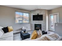 Bright living room featuring a modern fireplace, large window, and comfortable seating area at 9901 Trailwood Dr # 2109, Las Vegas, NV 89134