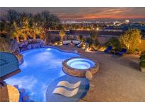 Resort-style pool boasts a rock waterfall, jacuzzi, tanning ledge, and fire pit seating area, with city views at 10084 Terrastone Dr, Las Vegas, NV 89148