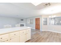 Bright living area with a decorative fireplace, wood-look floors, and white kitchen island at 1201 Sulphur Springs Ln # 101, Las Vegas, NV 89128