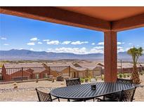 Enjoy mountain views from this covered patio with wrought iron table and chairs for outdoor dining at 1424 Pin Cushion Rdg, Mesquite, NV 89034