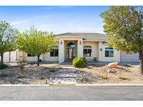 Charming single-story home with a stucco exterior, arched windows, and desert landscaping at 2500 S Zephyr Ave, Pahrump, NV 89048